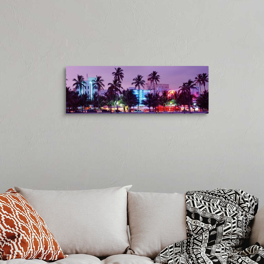 A bohemian room featuring View from the shore of Ocean Driveos art deco neon signs and palm trees.
