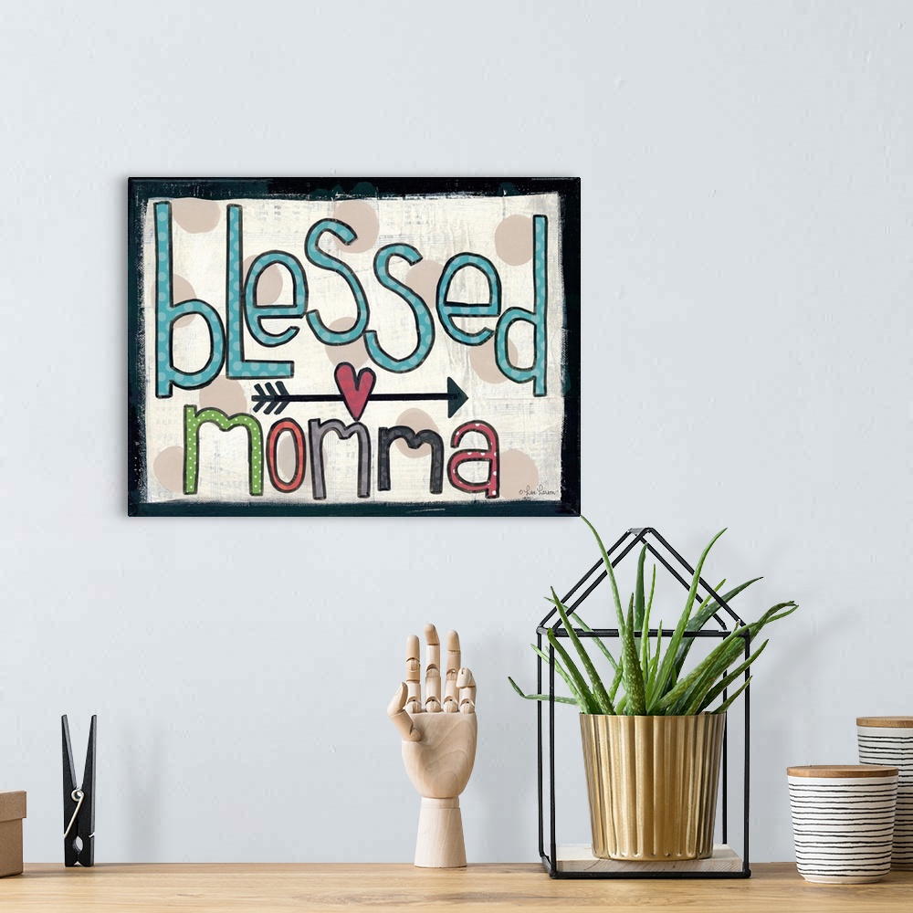 A bohemian room featuring Handwritten typography art reading "blessed momma," with an arrow and heart motif.