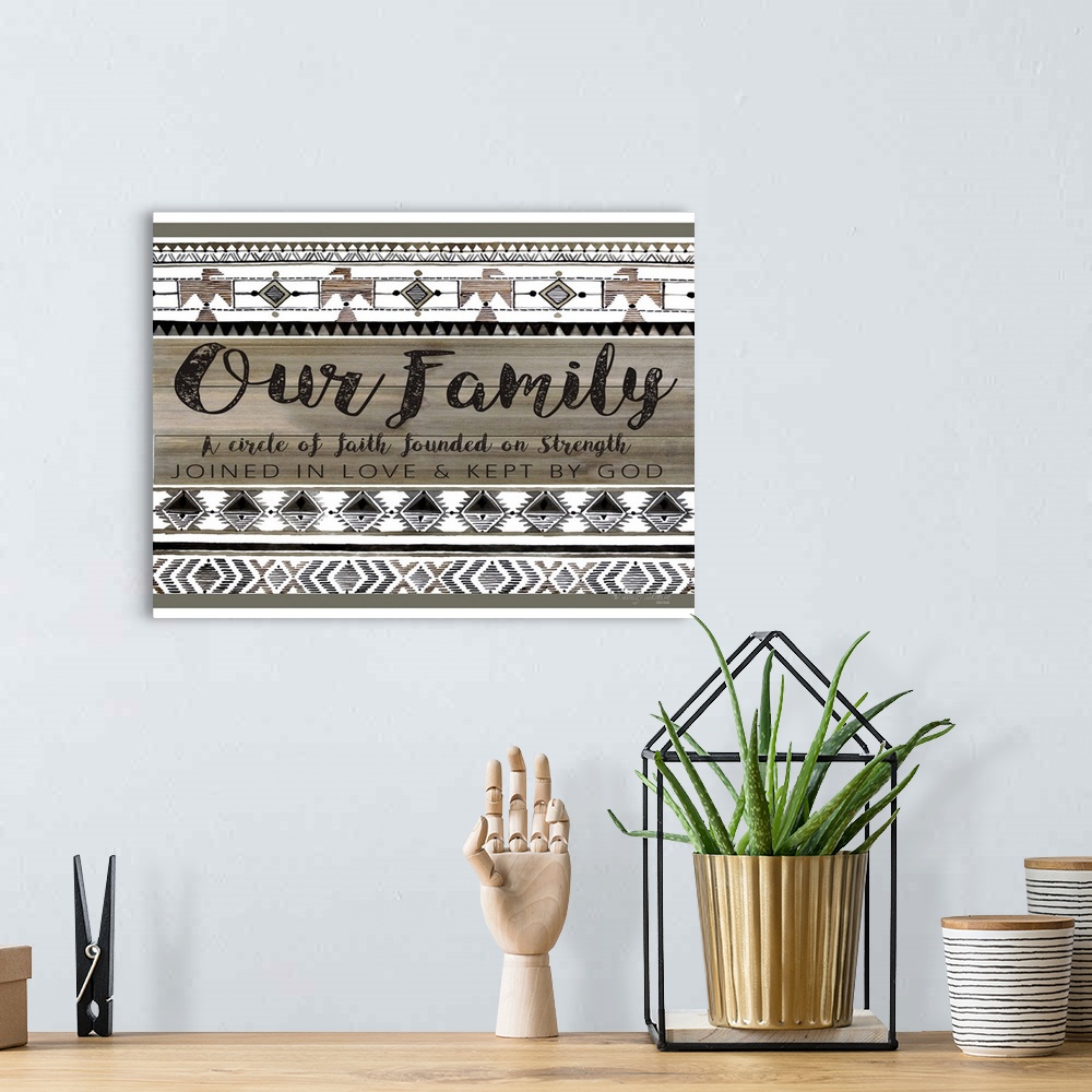 A bohemian room featuring Decorative artwork featuring geometric southwestern designs and a family sentiment.