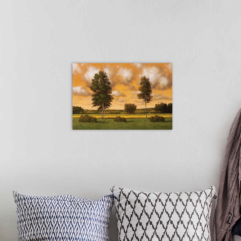 A bohemian room featuring Painting of two tall trees in a field against an orange sunset sky.