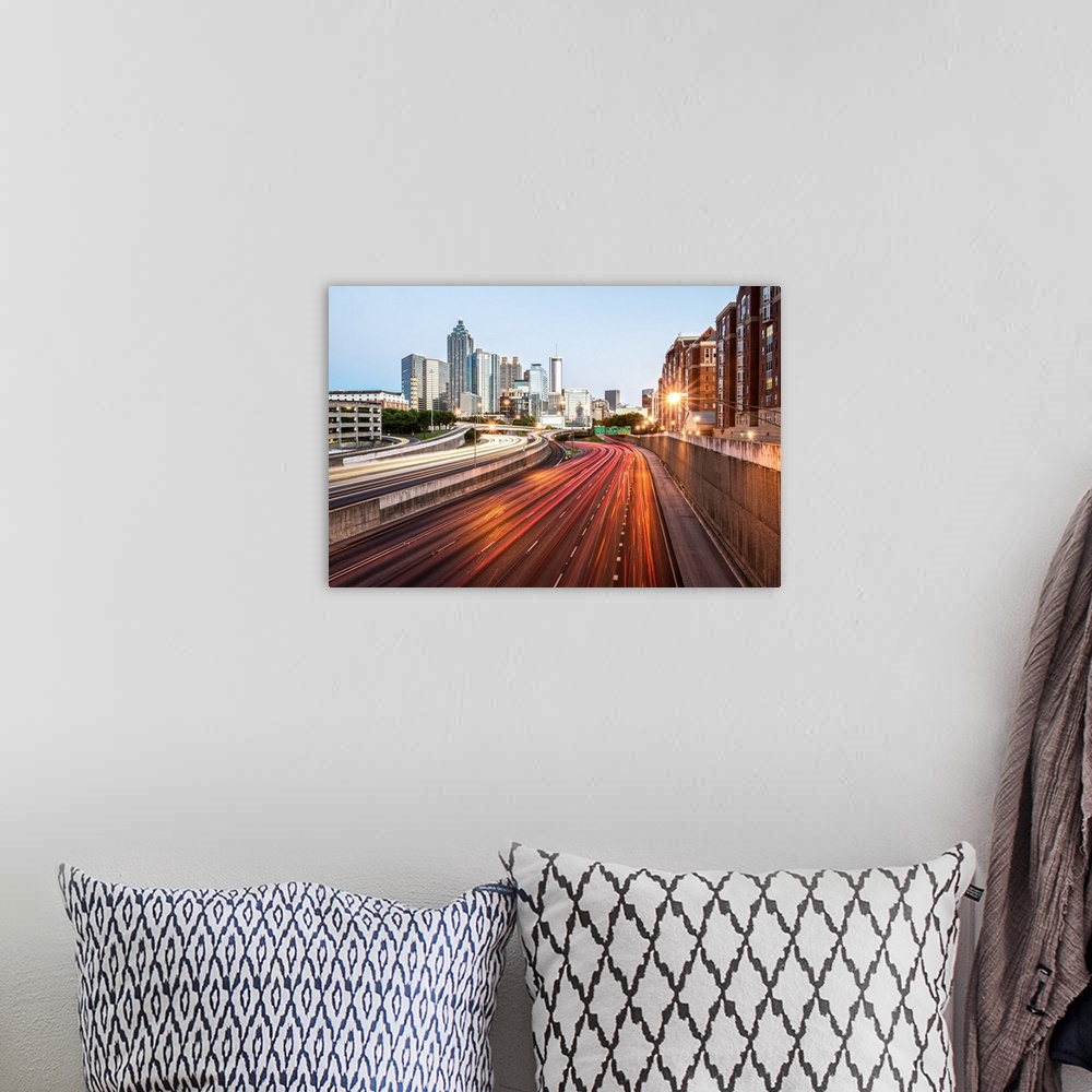 A bohemian room featuring Light trails on the street from passing vehicles leading towards the city skyline of Atlanta, Geo...
