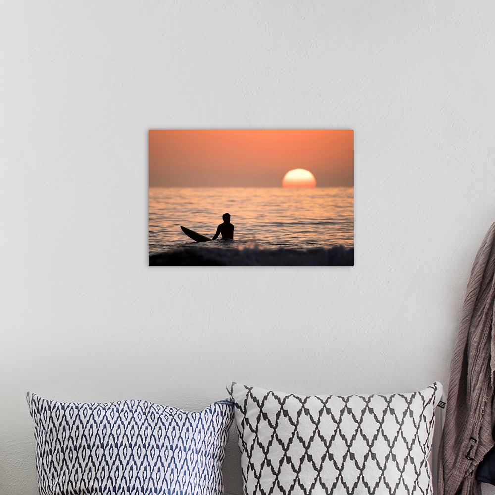 A bohemian room featuring Silhouetted photograph of a man sitting on his surfboard in the Pacific Ocean on the coast of San...