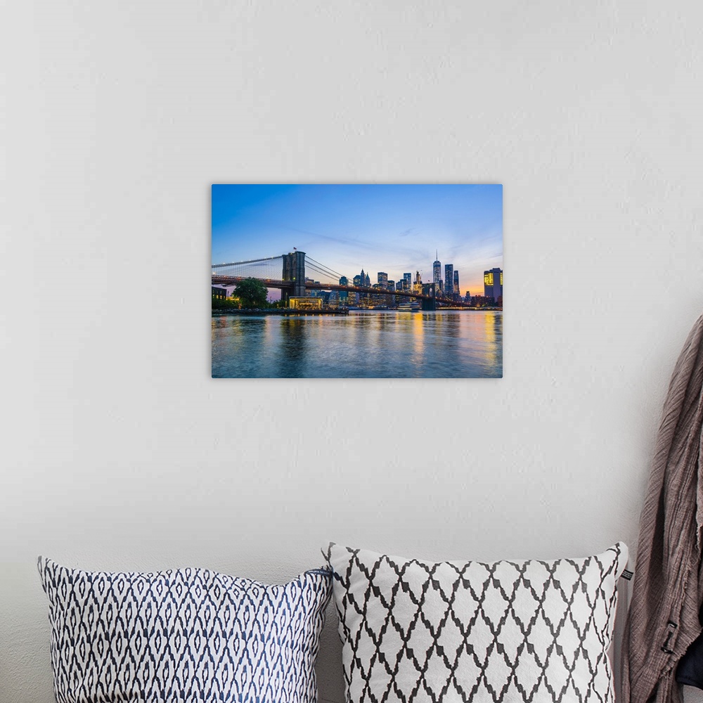 A bohemian room featuring Brooklyn Bridge and Manhattan skyline at dusk, viewed from the East River, New York City
