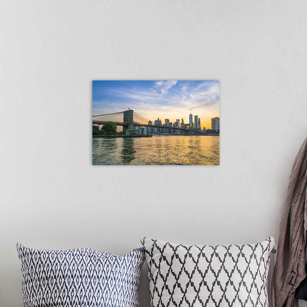 A bohemian room featuring Brooklyn Bridge and Manhattan skyline at dusk, viewed from the East River, New York City