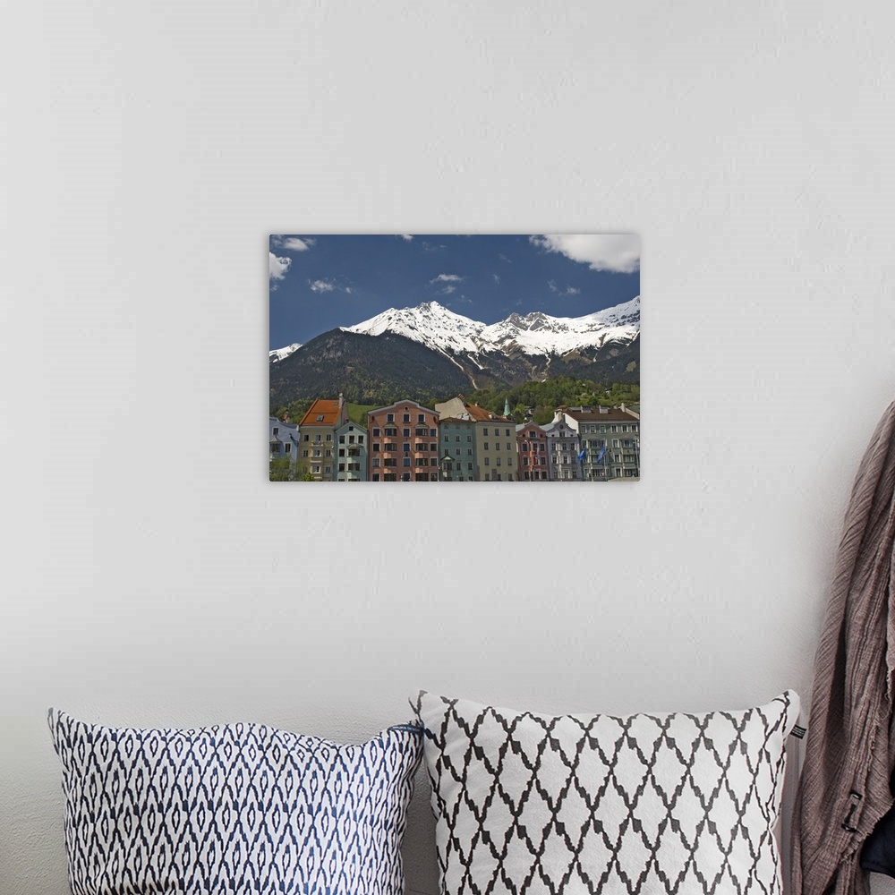 A bohemian room featuring Candy coloured houses with backdrop of mountains in spring snow, Innsbruck, Austria