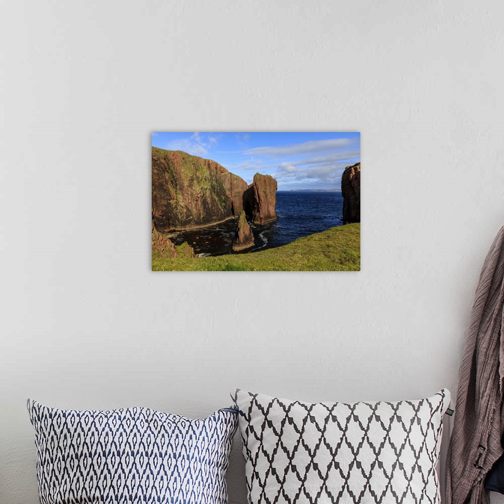 A bohemian room featuring North Ham, lichen covered huge red granite cliffs and stacks, Muckle Roe Island, Shetland Isles, ...