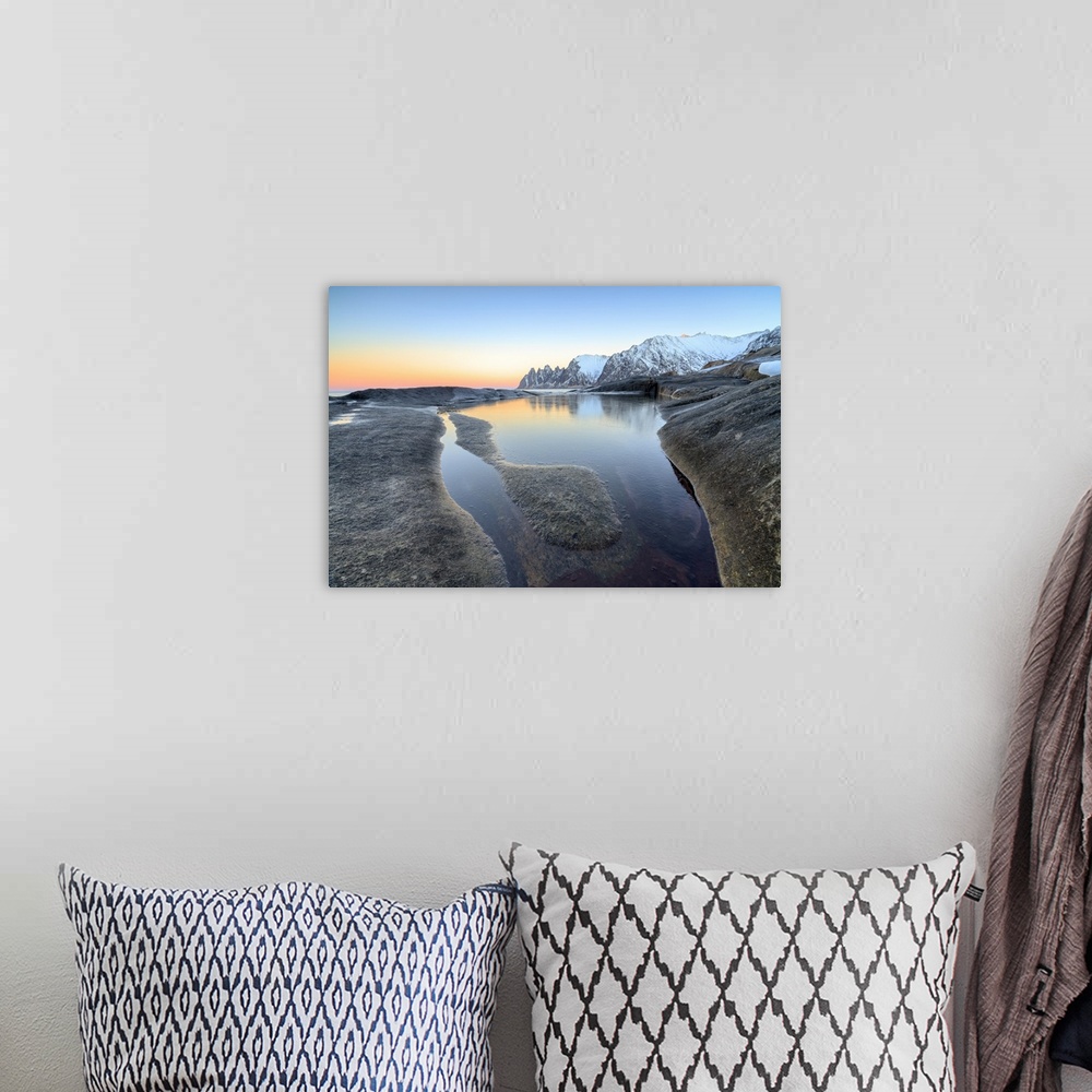 A bohemian room featuring Orange sky at sunset reflected on snowy peaks and the frozen sea surrounded by rocks Tungeneset, ...