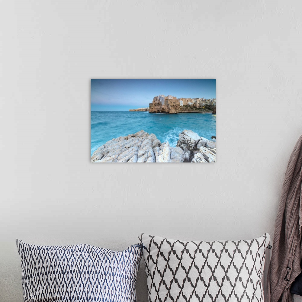 A bohemian room featuring Turquoise sea at dusk framed by the old town perched on the rocks, Polignano a Mare, Province of ...