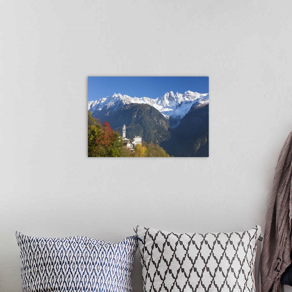 A bohemian room featuring The colorful trees frame the alpine church and the snowy peaks, Soglio, Bregaglia Valley, Canton ...