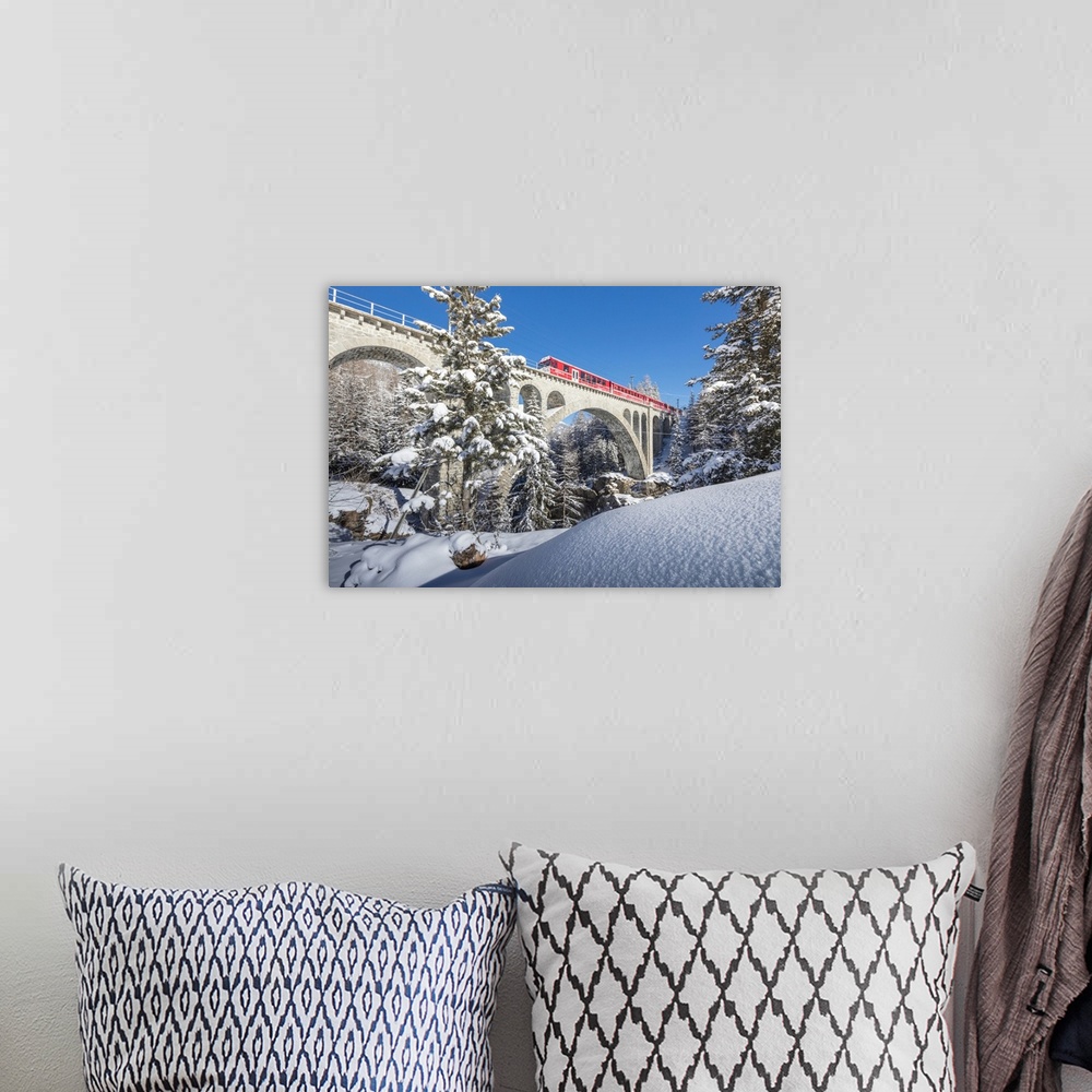 A bohemian room featuring The red train on viaduct surrounded by snowy woods, Cinuos-Chel, Canton of Graubunden, Engadine, ...