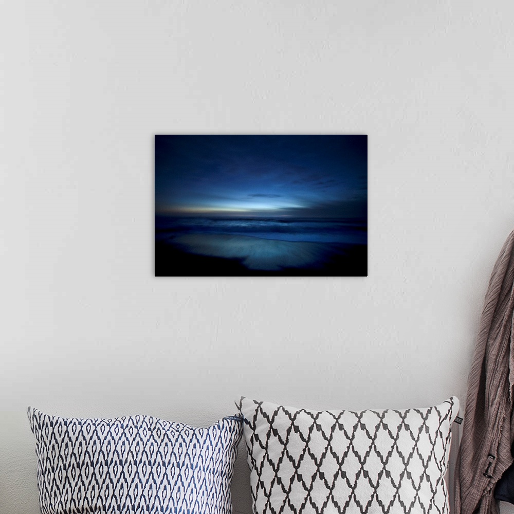 A bohemian room featuring Landscape, oversized photograph of deep blue ocean waters along the beach, surrounded by the dark...