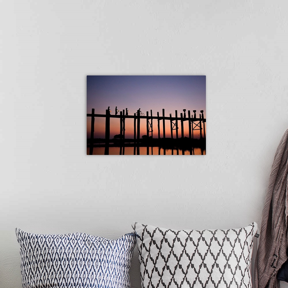 A bohemian room featuring Photograph of people walking and biking across a bridge made of tall wooden beams over the ocean ...