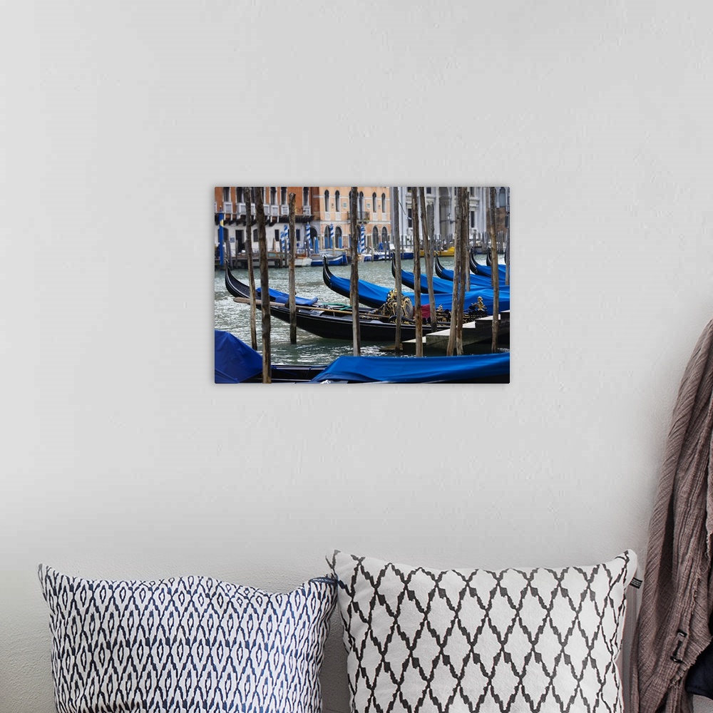 A bohemian room featuring Photograph taken of a river in Venice that is lined with gondola boats that are tied up and have ...