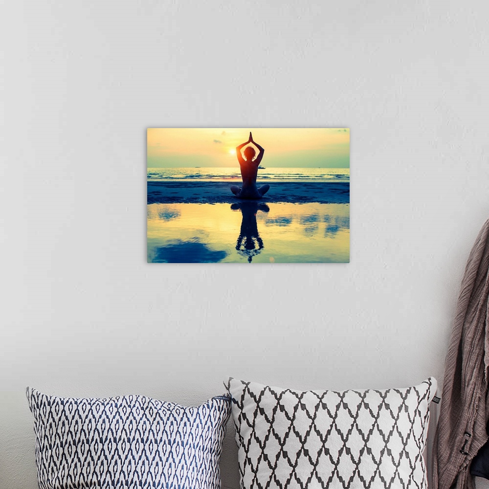 A bohemian room featuring Woman sitting in lotus pose on the beach during sunset
