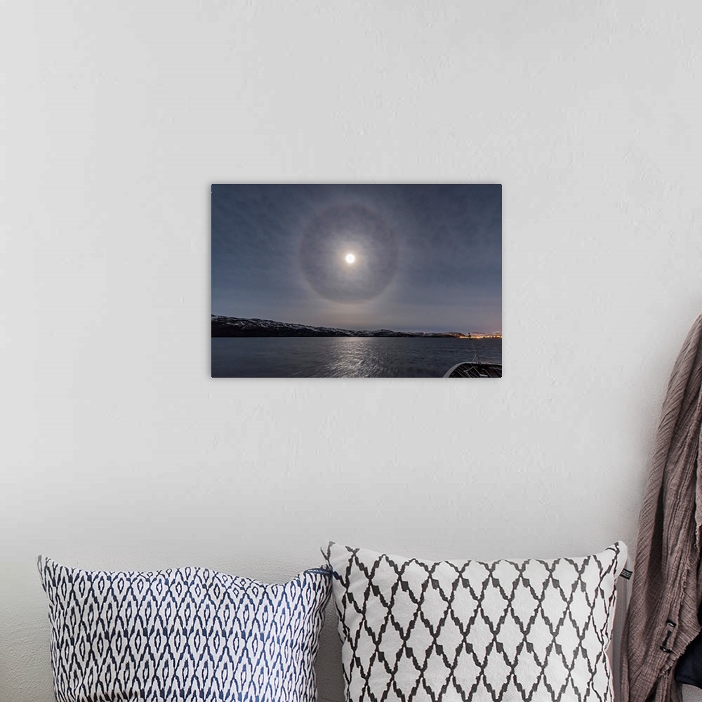 A bohemian room featuring A halo around the nearly full moon over the Barents Sea in northern Norway.