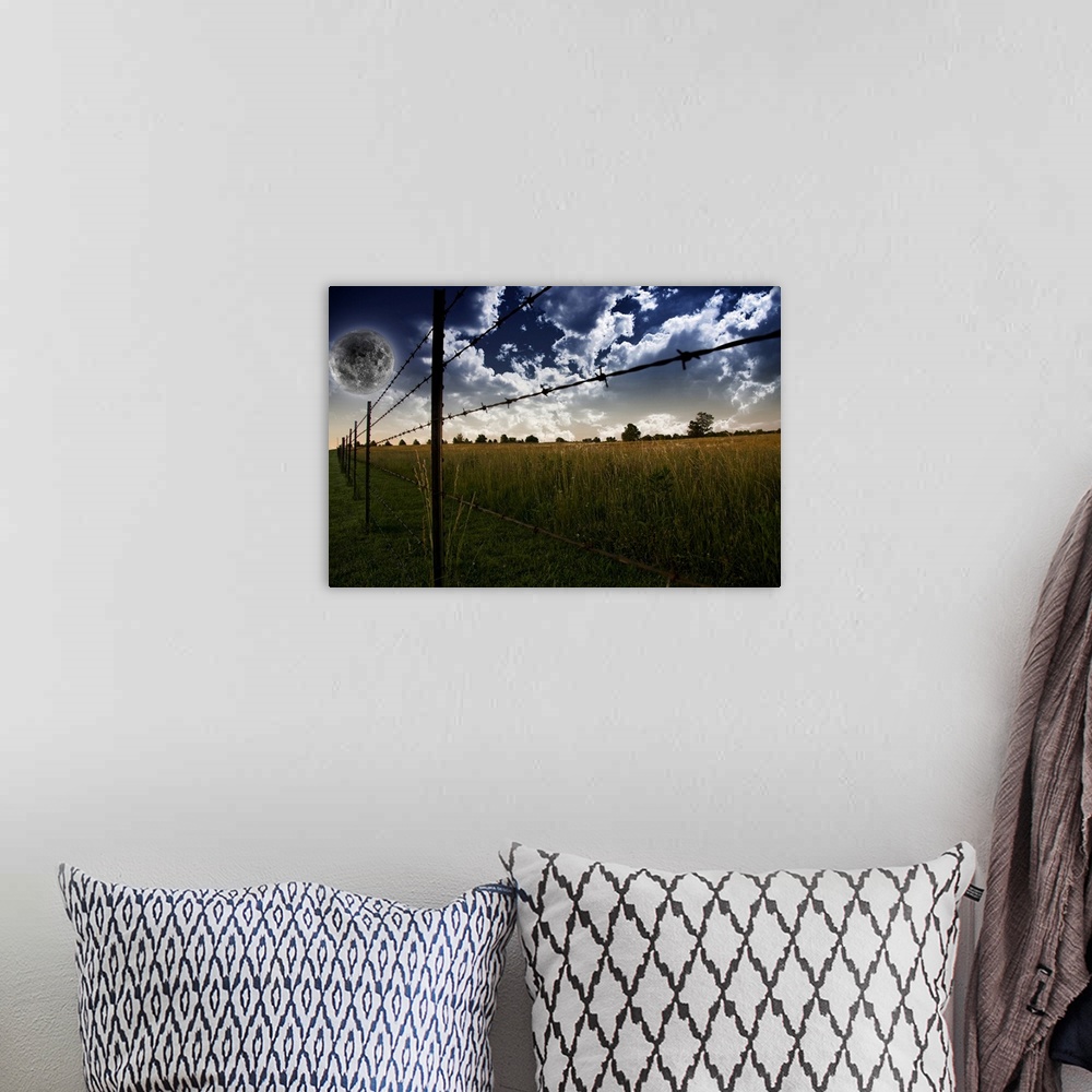 A bohemian room featuring Fence on a farm field with giant full moon in a cloudy sky.
