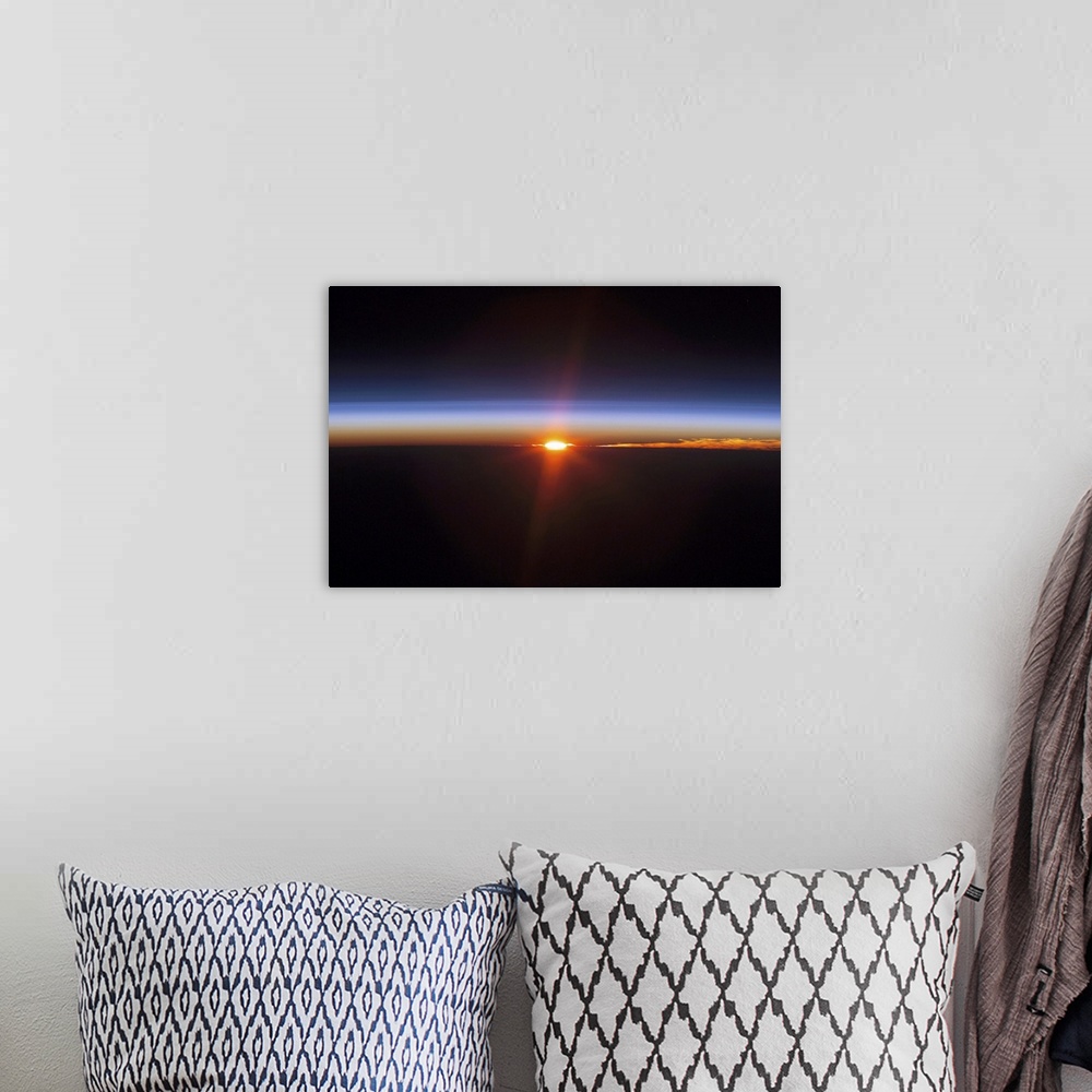 A bohemian room featuring Aerial photograph of a clear sky at dusk with glowing sun rays.