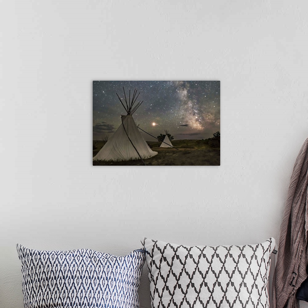 A bohemian room featuring Mars and the Milky Way over the tipis in Grasslands National Park, Saskatchewan, Canada.