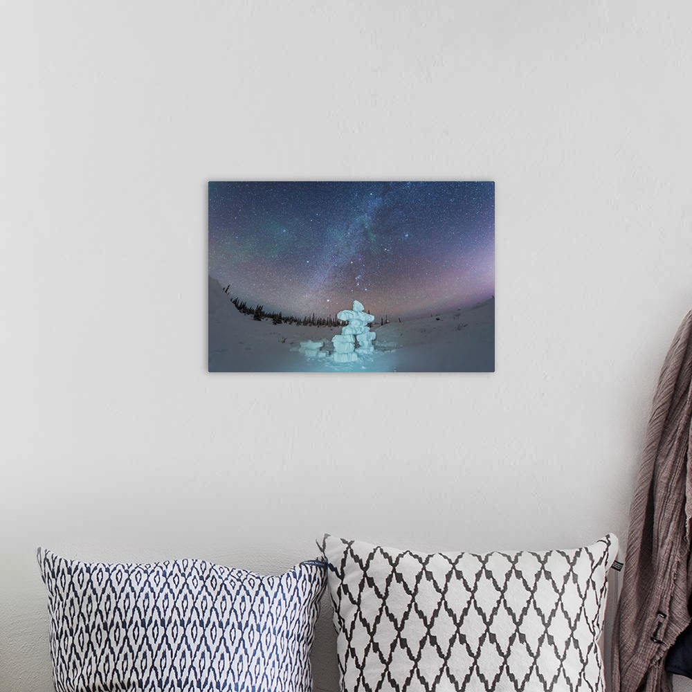 A bohemian room featuring Milky Way and winter stars over a mock-up inukshuk figure made of snow, Canada.
