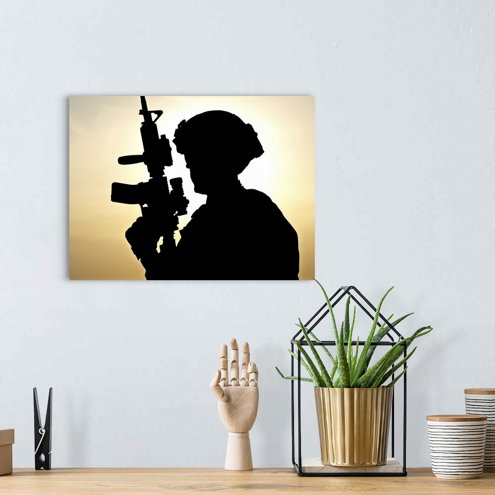 A bohemian room featuring Silhouette of young soldier against the sun.
