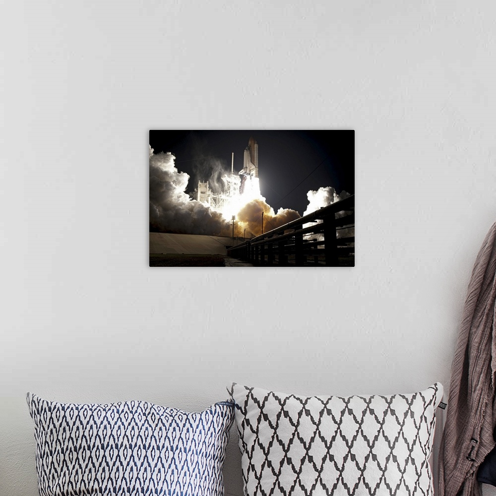 A bohemian room featuring Large horizontal photograph of the space shuttle Endeavour taking off from the launch pad at nigh...