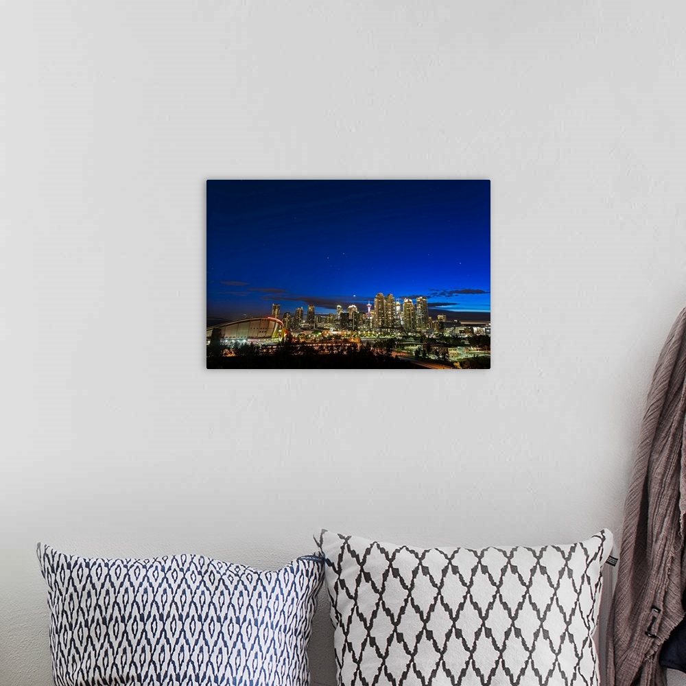 A bohemian room featuring Venus and stars setting over the skyline of Calgary, Canada.