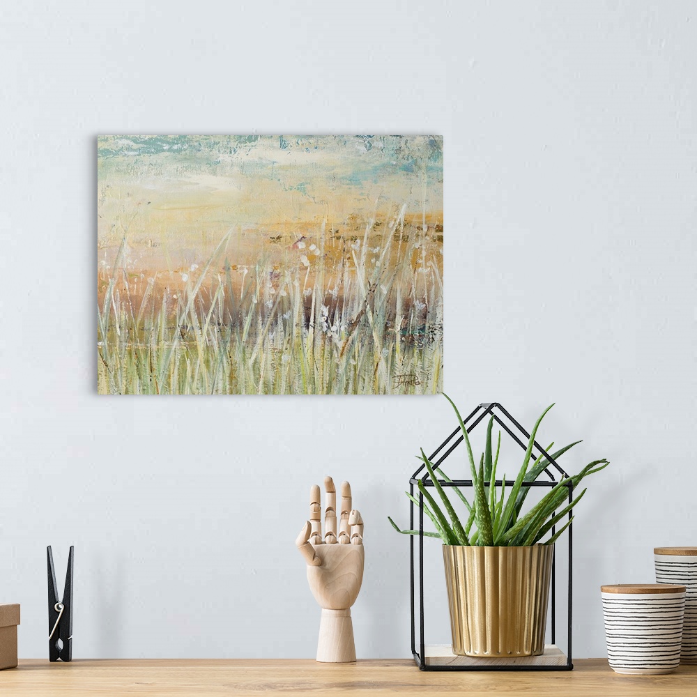 A bohemian room featuring A contemporary landscape painting with pale colors and white, tall grass in the foreground.