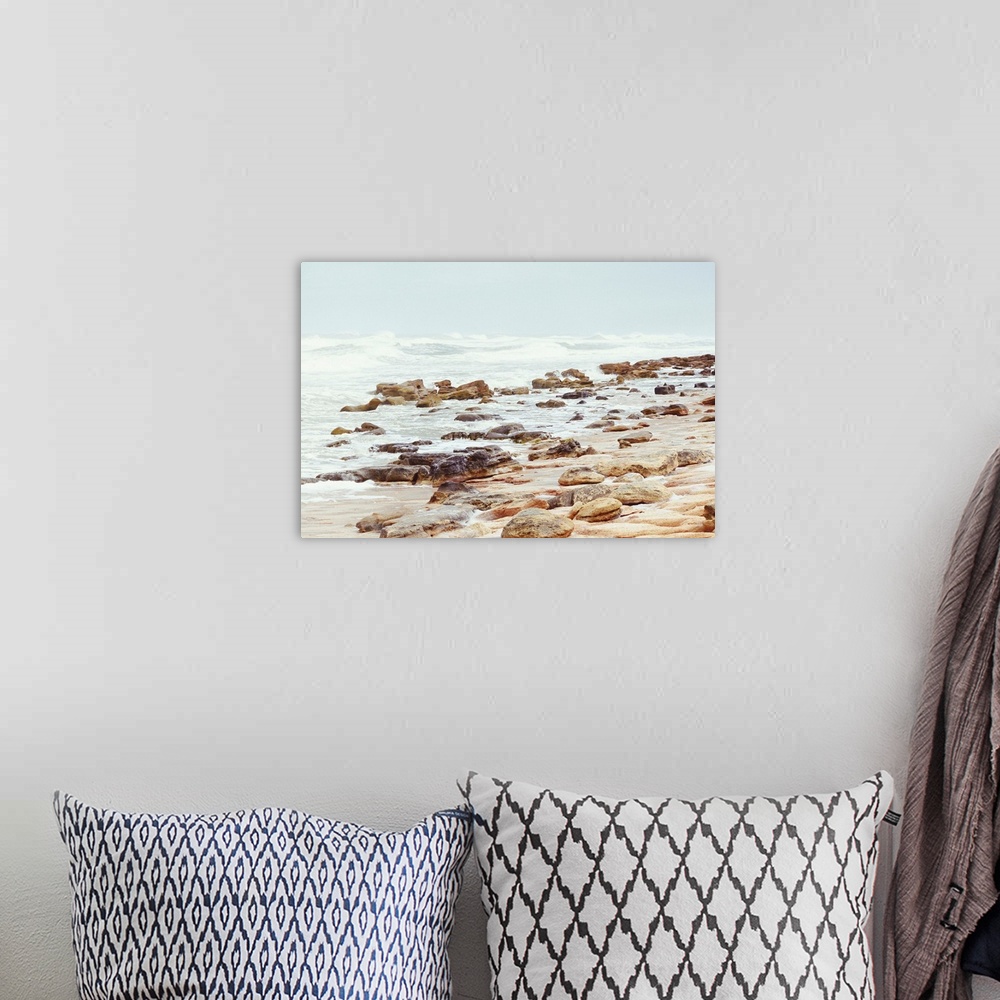 A bohemian room featuring A photograph of a rocky beach shore.