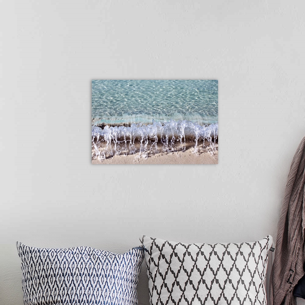 A bohemian room featuring Photograph of a small wave hitting the shore of a beach.