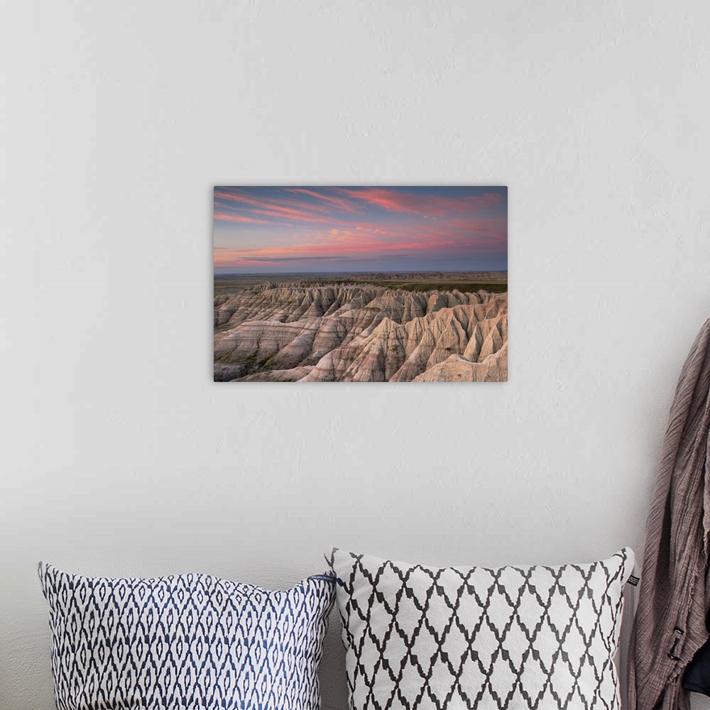 A bohemian room featuring Pink clouds at dawn over the pointed rocky landscape of the South Dakota badlands.