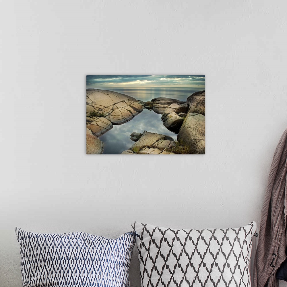 A bohemian room featuring A rocky shore with calm sea and rock pool
