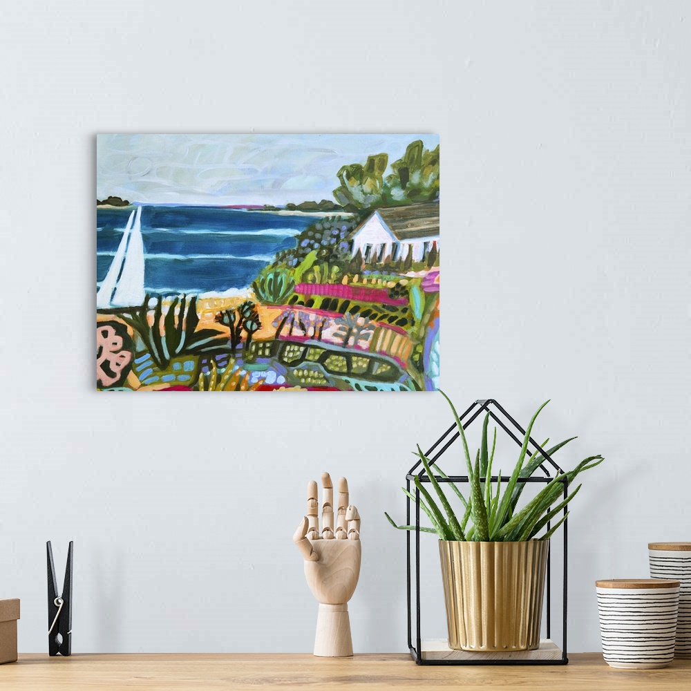 A bohemian room featuring Colorful artwork of a house on the beach with a sailboat on the water.