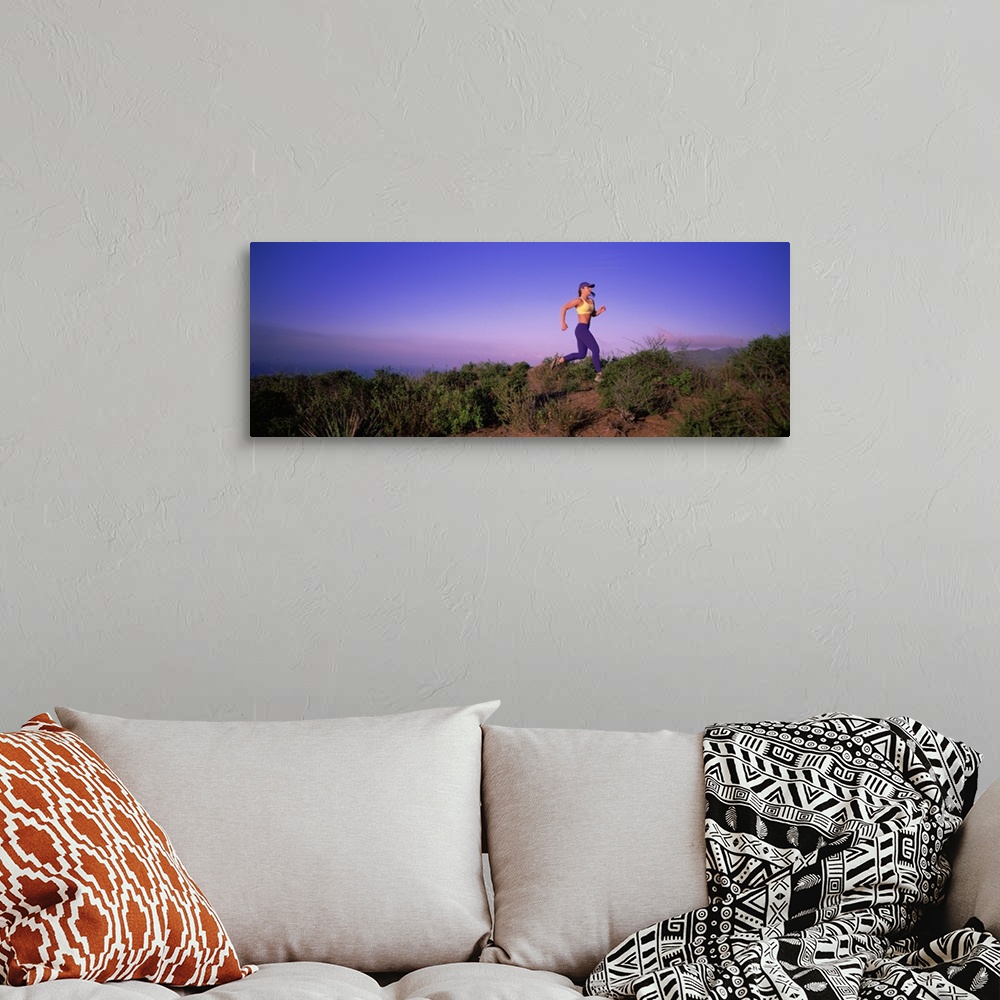 A bohemian room featuring Side profile of a young woman running on a hill