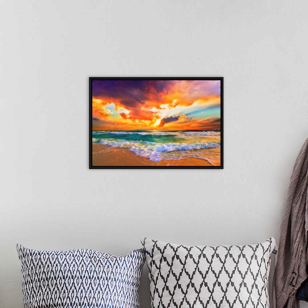 A bohemian room featuring A red, orange and purple sunset on the beach. Beautiful ocean waves roll onto the sea shore.