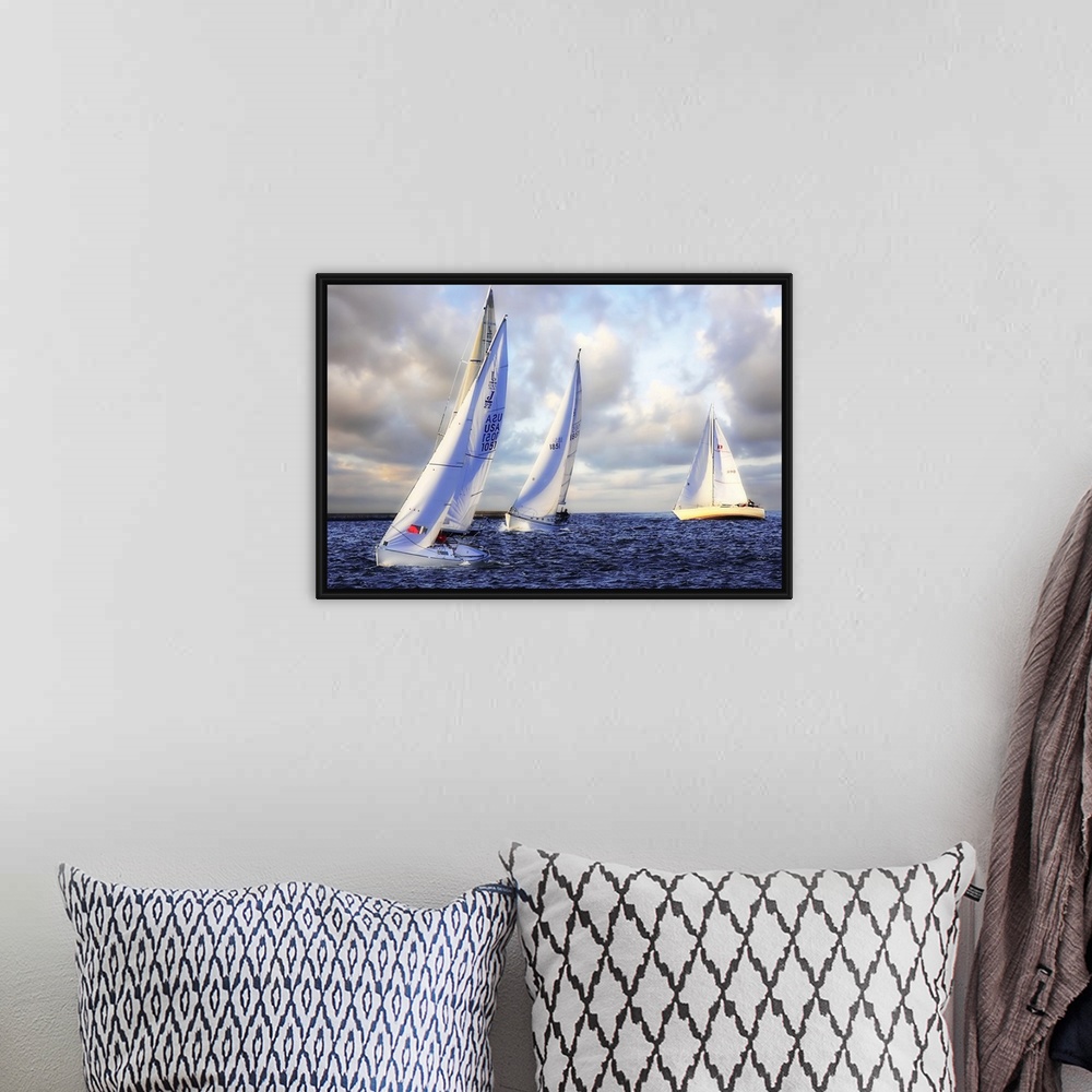 A bohemian room featuring Several sail boats are pictured in open water and the sky filled with grey clouds.