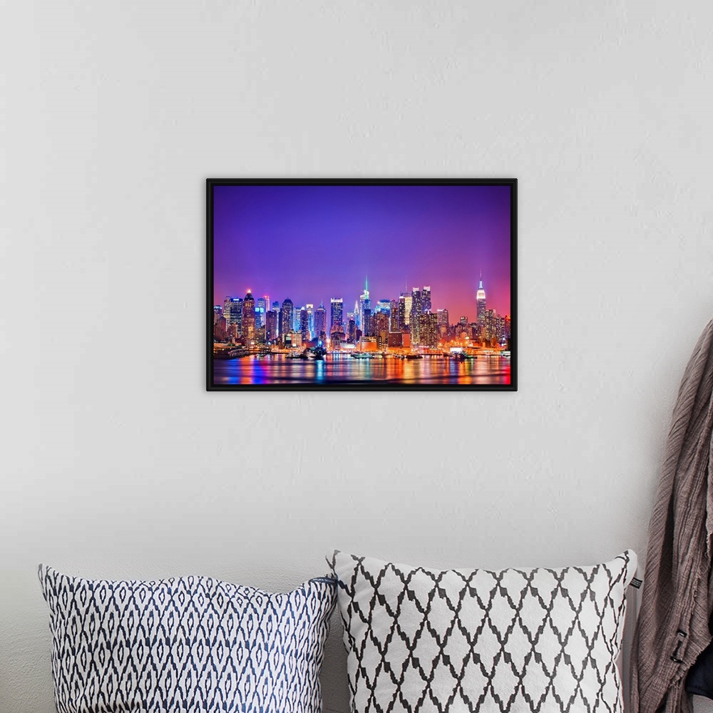 A bohemian room featuring Photograph of New York skyline at night with the Hudson River in foreground.  The building lights...