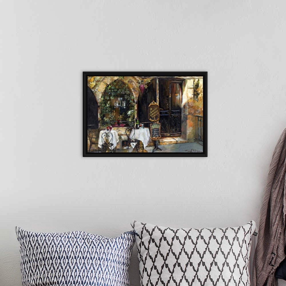 A bohemian room featuring An impressionistic painting of an outdoor cafo in a rustic European city.
