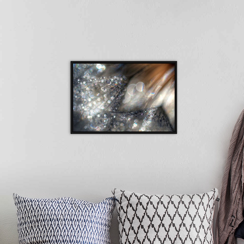 A bohemian room featuring Large abstract canvas print of light and earth toned colors with bright and dark circles of light...