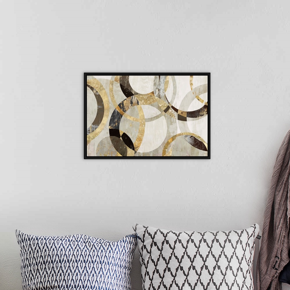 A bohemian room featuring Geometric abstract artwork with circular rings in shades of brown, gold, and gray.