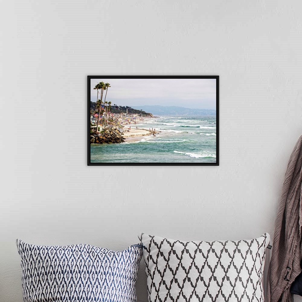 A bohemian room featuring Landscape photograph of the La Jolla coast filled with beach goers and palm trees.