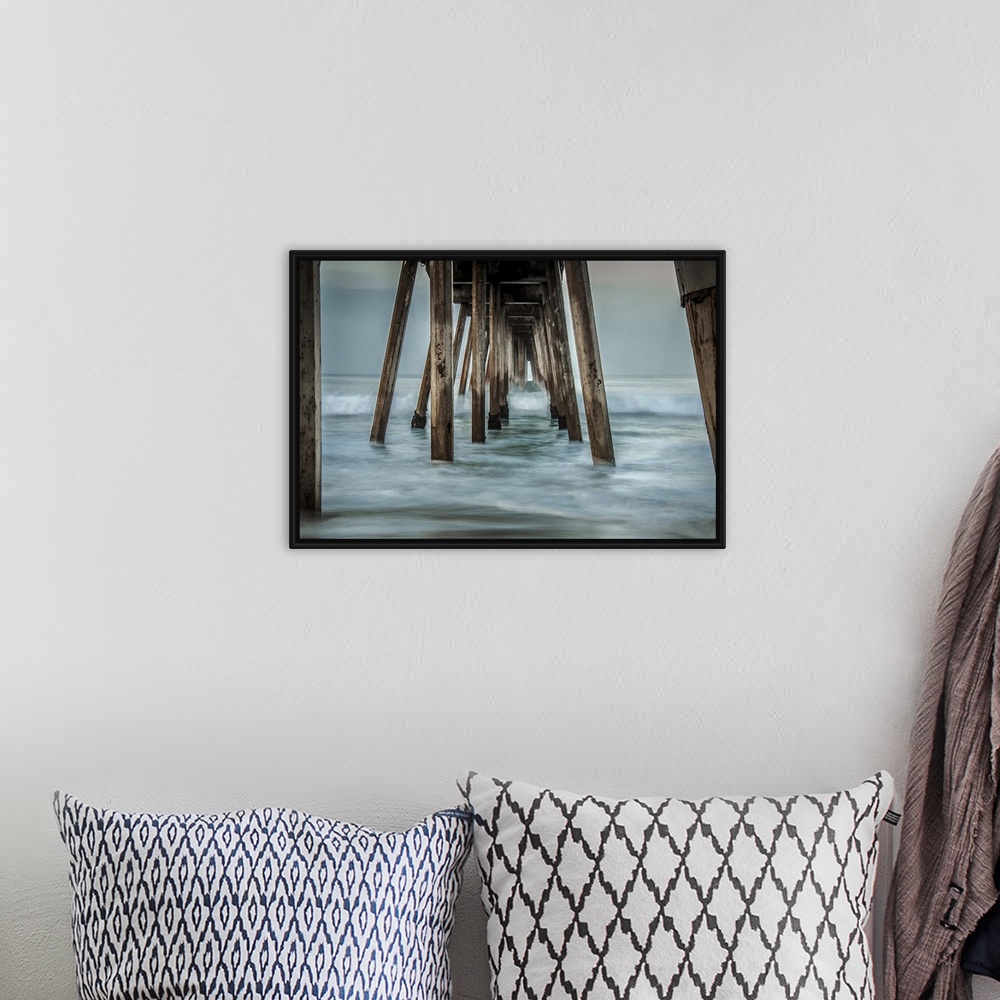 A bohemian room featuring View from below of a wooden pier stretching out into the ocean.