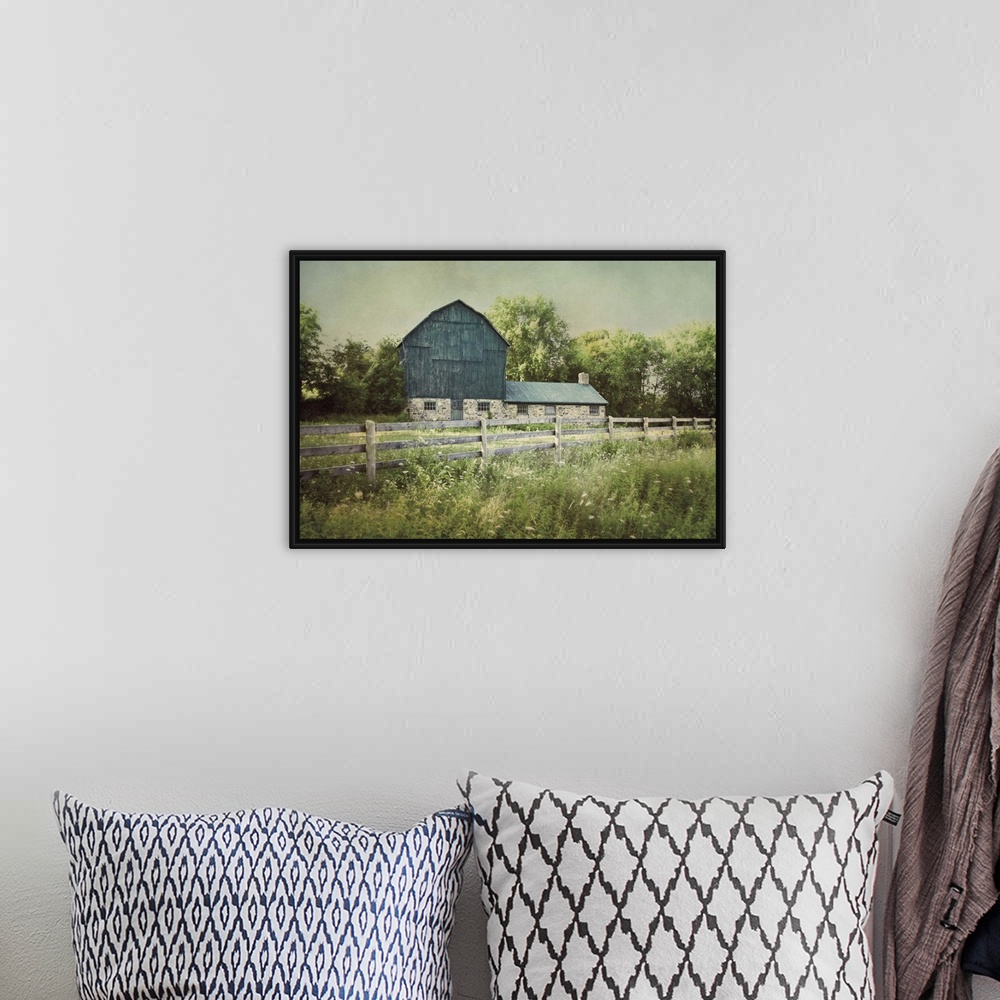 A bohemian room featuring A photograph of a blue barn.