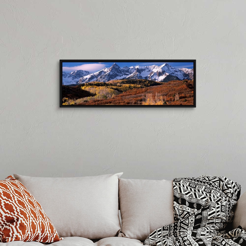 A bohemian room featuring Giant landscape photograph of a golden brown Colorado valley in front of snow covered mountains u...