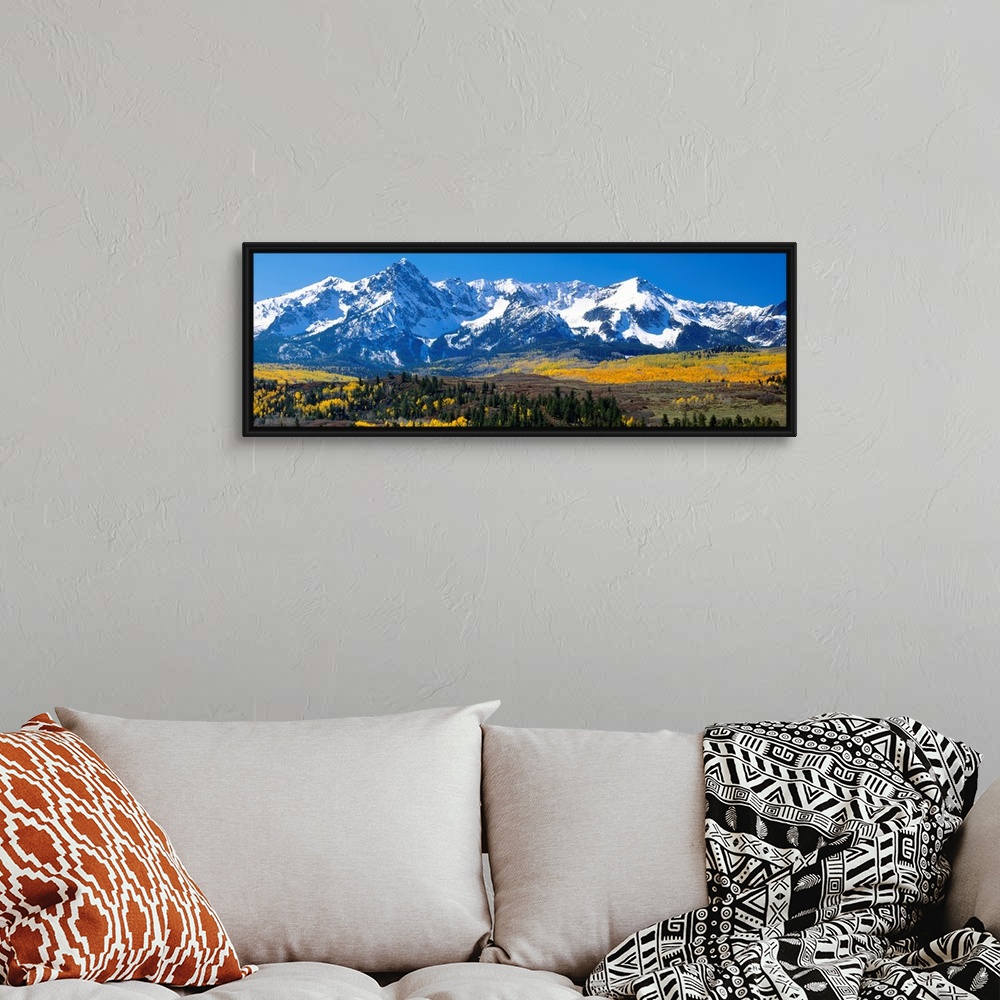 A bohemian room featuring Panoramic image of a wilderness area at the base of a snowy mountain range.
