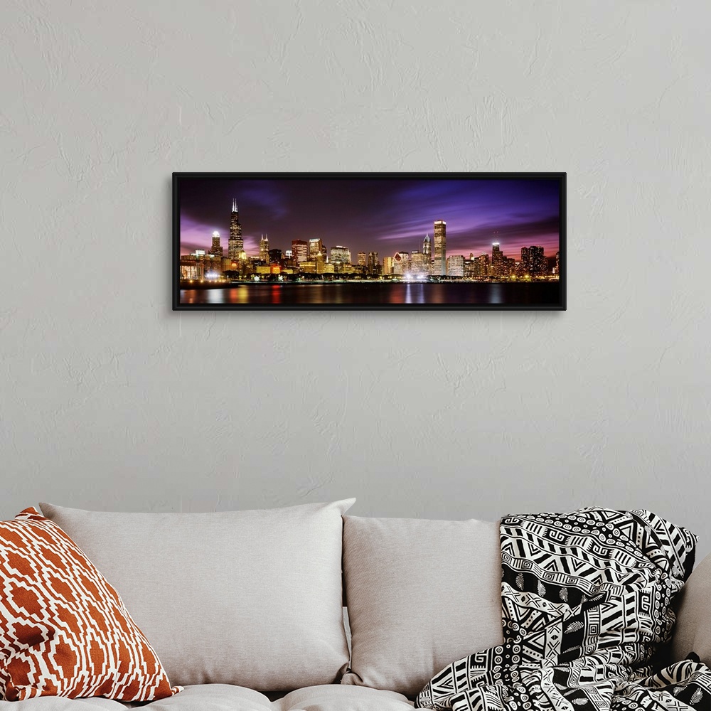 A bohemian room featuring A big cityscape panoramic of downtown Chicagoos lights reflecting off Lake Michigan at night.