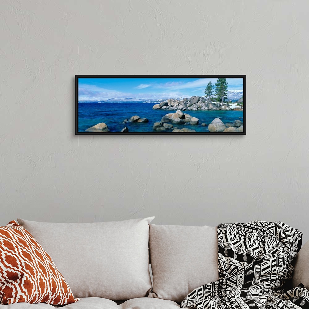 A bohemian room featuring A panoramic photograph taken at eye level this home wall art shows the boulder covered shores of ...
