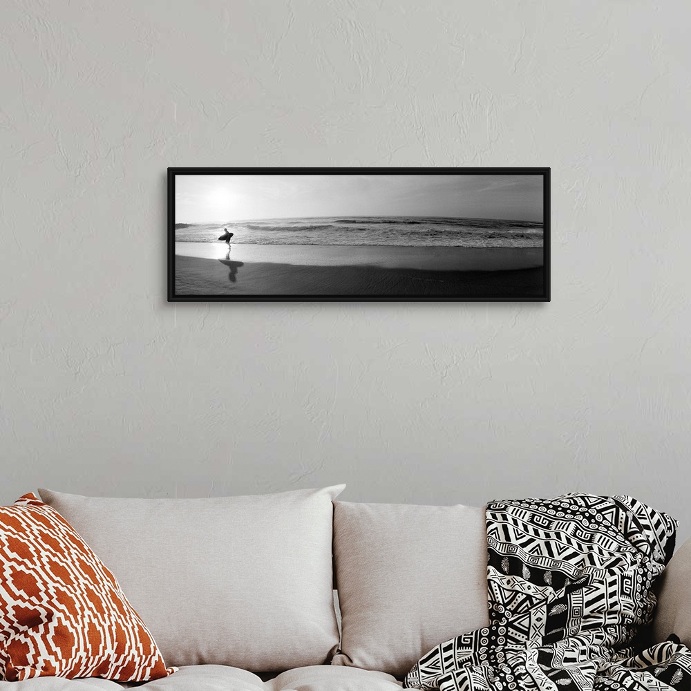 A bohemian room featuring Panoramic photograph of a surfer walking along a sandy beach in San Diego, California.  The tide ...