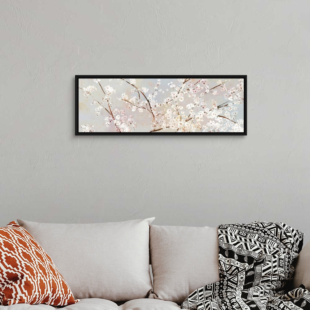 A bohemian room featuring A long panoramic painting of a large branch of white cherry blossoms.