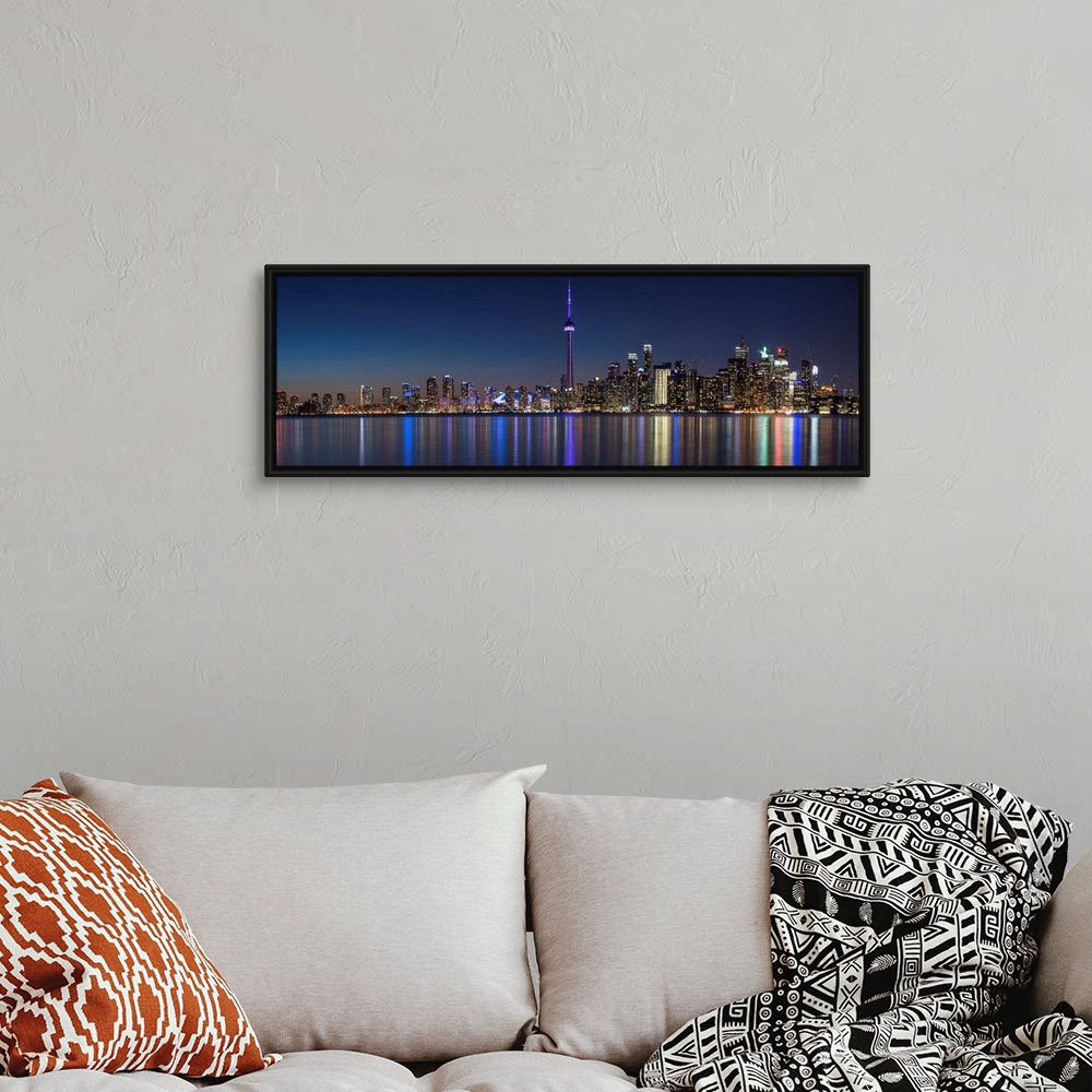 A bohemian room featuring Panoramic photo of the Toronto city skyline with lights reflected in the water at night.