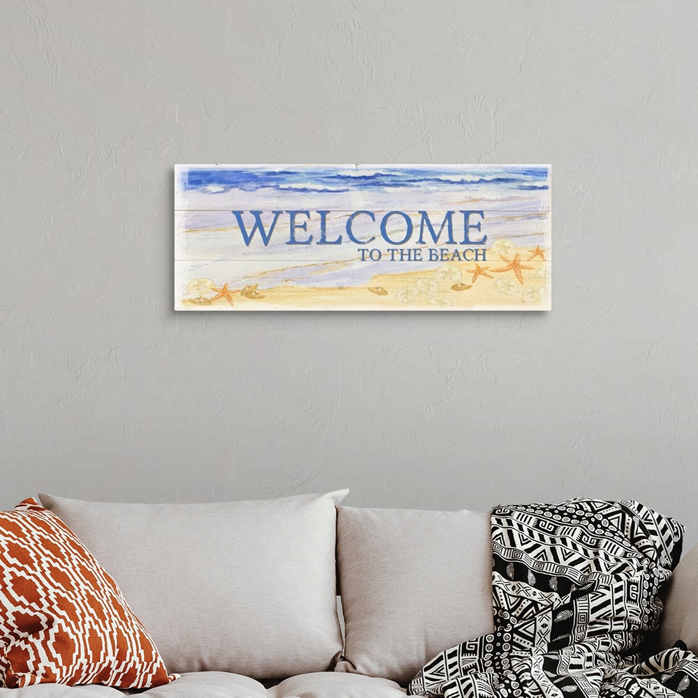 A bohemian room featuring A watercolor beach painting on a wood panel design with the words 'Welcome To The Beach'.